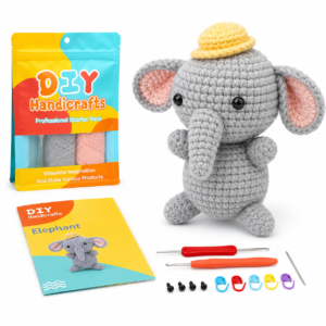 Kit de loisirs créatifs d'éléphant amigurumi avec fil, livre de patrons, outils et ensemble de crochets disposés à côté d'un jouet éléphant en crochet gris et d'un sac coloré de matériaux d'artisanat à faire soi-même.
