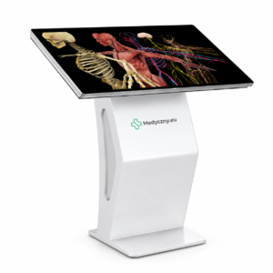 Kiosque médical tactile autonome affichant un schéma anatomique humain détaillé (squelette, muscles, nerfs) sur l'écran, avec le logo 'Medyczny.eu' sur le support.